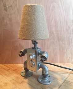 a lamp made out of an old fashioned machine with a fabric shade on it's head