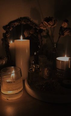 some candles are sitting on a table next to a mirror