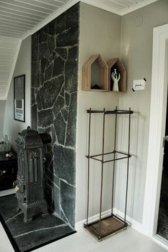 a stone fireplace in a living room next to a wall with shelves on the side