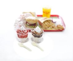 miniature food items displayed on white surface with red tray