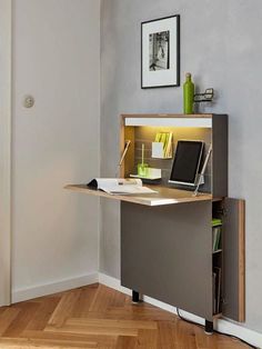 a laptop computer sitting on top of a wooden desk next to a book shelf and lamp