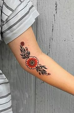 a woman's arm with a flower tattoo on the left side of her arm