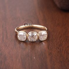 three stone ring sitting on top of a wooden table