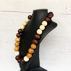 This colorful wood bead necklace was hand beaded using a mix of large 25mm round dark brown, tan, and beige wooden beads in a modern color block design. The necklace measures approximately 28 inches in length and is fastened with a silver clasp. The end result is a cool bohemian piece that fits in perfectly with almost any outfit! Perfect for any gender. Length can be adjusted if needed - just ask! Wood represents a sense of earthiness, spirituality, creativity, liberty, prosperity, health, and Adjustable Brown Round Beaded Necklace, Rustic Brown Wooden Bead Necklaces, Adjustable Round Brown Beaded Necklace, Adjustable Brown Beaded Round Necklace, Adjustable Brown Beaded Necklace, Rustic Brown Wooden Beaded Necklaces, Rustic Brown Wooden Beads Necklace, Brown Wooden Beaded Jewelry, Rustic Brown Necklace With Large Beads