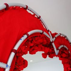 a red chair with white piping and flowers on it