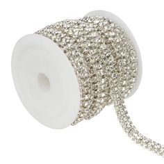 a roll of silver beaded ribbon on a white background