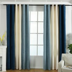 a living room filled with furniture and a window covered in blue drapes next to a white fireplace