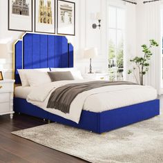 a bed with blue headboard in a white room