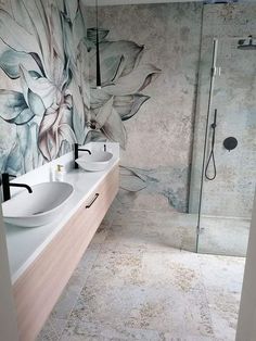 two white sinks sitting next to each other on a counter in front of a shower