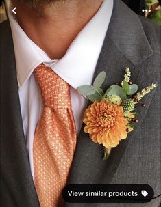 a man wearing an orange tie and flower boutonniere on his lapel