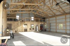 the inside of a large building with lots of windows and wood beams on the ceiling