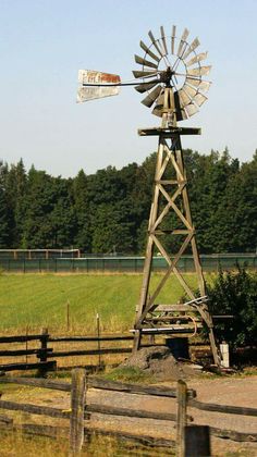 an old windmill sitting in the middle of a field