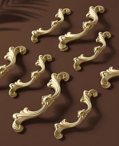 the golden handles and finials are arranged on a brown surface