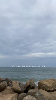 a person standing on rocks near the ocean