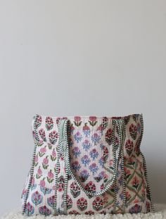 a purse sitting on top of a pile of white furnishing next to a wall