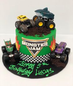 a birthday cake with monster trucks on top