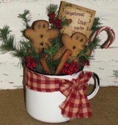 a mug filled with gingerbreads and christmas decorations