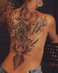 the back of a woman's body with tattoos on her upper and lower half