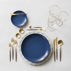 the table is set with silverware and gold utensils, including one black plate