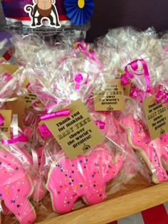 pink and white decorated cookies in plastic wrappers with tags on them for children's birthdays