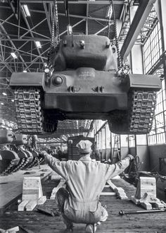 a man is sitting on the floor in front of a large crane with his arms outstretched