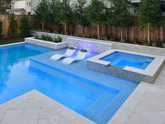 an empty swimming pool with lounge chairs in it