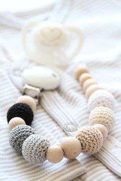 the necklace is made from wood beads and knitted with white, black, gray and beige yarn