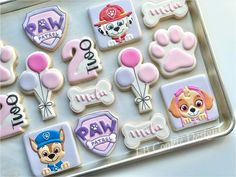 decorated cookies in the shape of dogs and paw patrol on a cookie sheet with pink icing