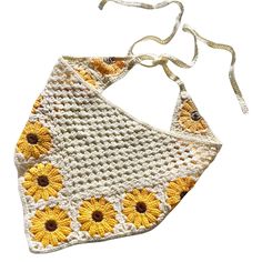 a crocheted sunflower purse hanging from a white string on a white background