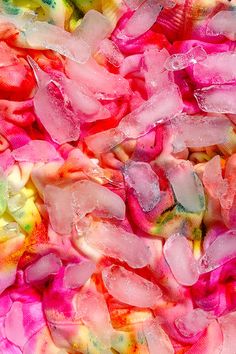 a pile of pink and yellow ice cubes sitting on top of each other