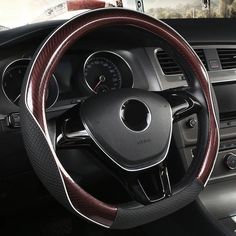 the interior of a car with steering wheel cover and dashboard gauges in black carbon fiber