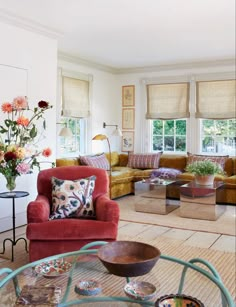 a living room filled with lots of furniture and flowers in vases on the coffee table