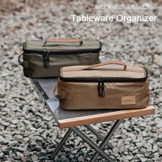 two cooler bags sitting on top of a table next to each other in the gravel