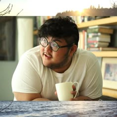 a man sitting at a table with a coffee cup