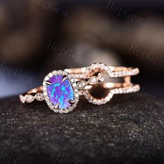 an opal and diamond ring set on top of a rock