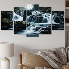 a living room with a couch and several paintings on the wall, including a waterfall