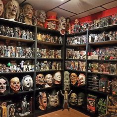 a room filled with lots of different types of halloween masks on the walls and shelves