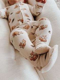 a baby laying on top of a white bed