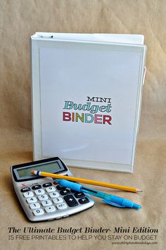 a calculator and pencils are sitting next to a binder with the words mini budget binder on it