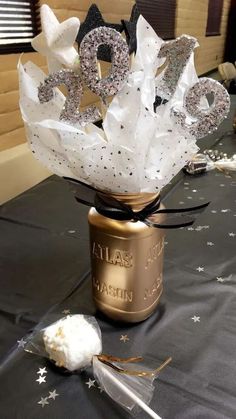 a table topped with a jar filled with white frosting and some stars on it