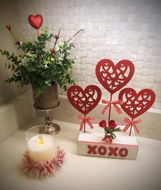 a vase with flowers and two hearts on it next to a box that says xoxo