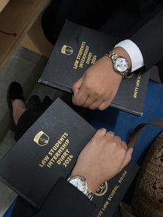 two people in suits hold their passport and watch