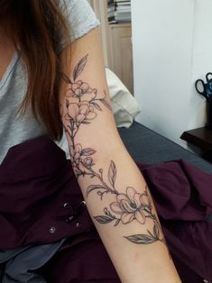 a woman with a flower tattoo on her arm