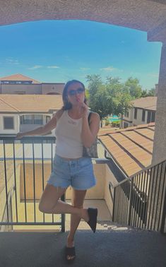 a woman standing on top of a balcony talking on a cell phone