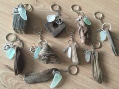 several different types of sea glass and driftwood keychains on a wooden table