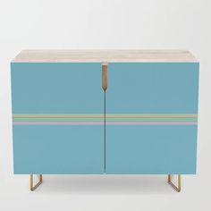 a blue cabinet with gold legs and a wooden top