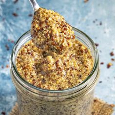 a spoon with some food in it on top of a glass jar filled with oatmeal