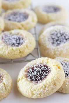 several cookies with powdered sugar on top are cooling on a rack in the kitchen