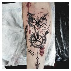 an owl and compass tattoo on the arm