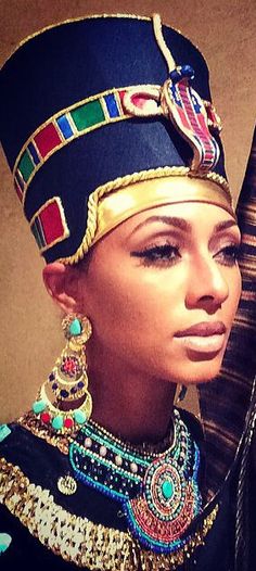 an egyptian woman wearing a headdress with jewels and jewelry on her neck, looking into the distance